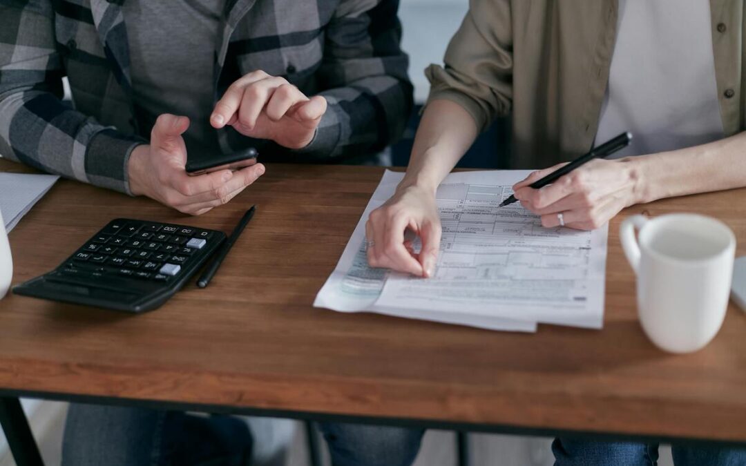 Two people completing tax forms