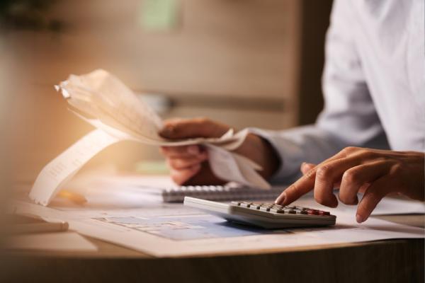 economist using calculator while going through bills and taxes