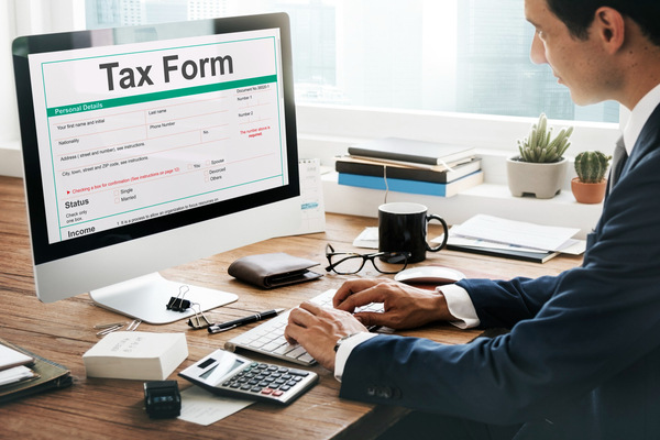 Man working on computer filling out online tax form