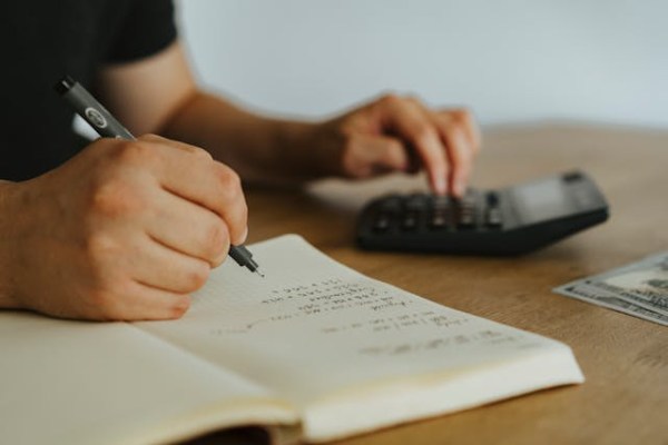 manual tax preparation with handwritten calculations and financial planning