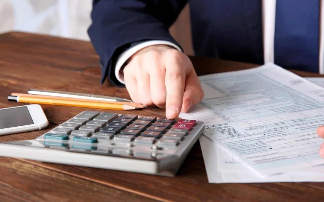 Tax professional calculating a tax levy using financial documents.