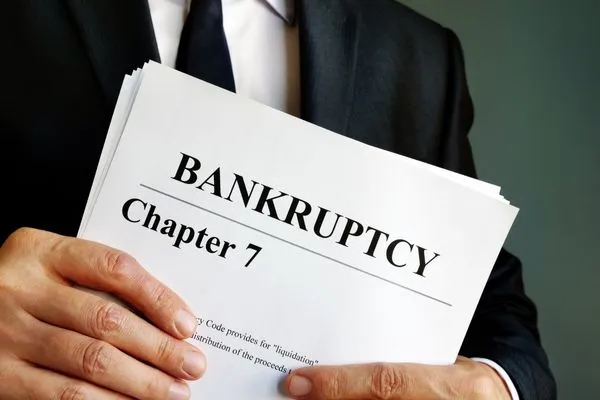 Man holding bankruptcy paperwork documents