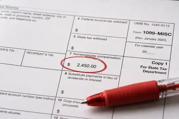 Close-up of corrected 1099 form with red ink marking a reporting error