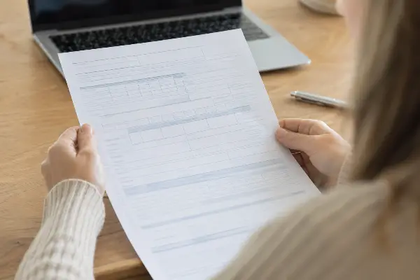 Close-up of a taxpayer holding a cancellation of debt tax form at a desk