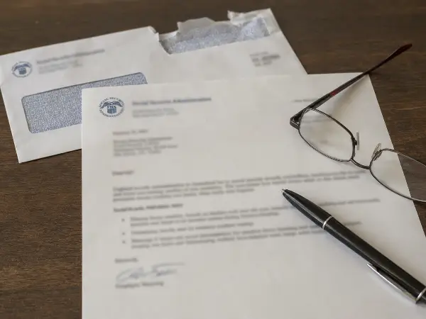 Social Security benefits letter beside an IRS envelope on a desk